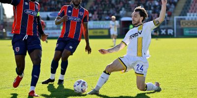Sonny Blu Lo-Everton of Torquay United challenges Christian Maghoma of Dagenham and Redbridge during the National League South Match between Dagenham and Redbridge and Torquay United at Chigwell Construction Stadium, Dagenham on 21 March 2026. Photo: Garry Bowden/PPAUK