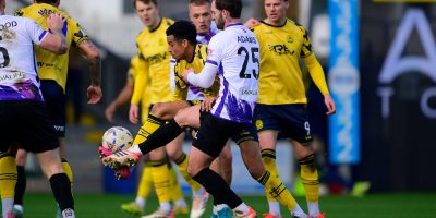 Louis Dennis of Torquay United challenges for the ball with Charlee Adams of Chelmsford City during the National League South match between Torquay United and Chelmsford City at Plainmoor, Torquay on Saturday 28th February 2026 - PHOTO: Frankie OKeeffe/PPAUK
